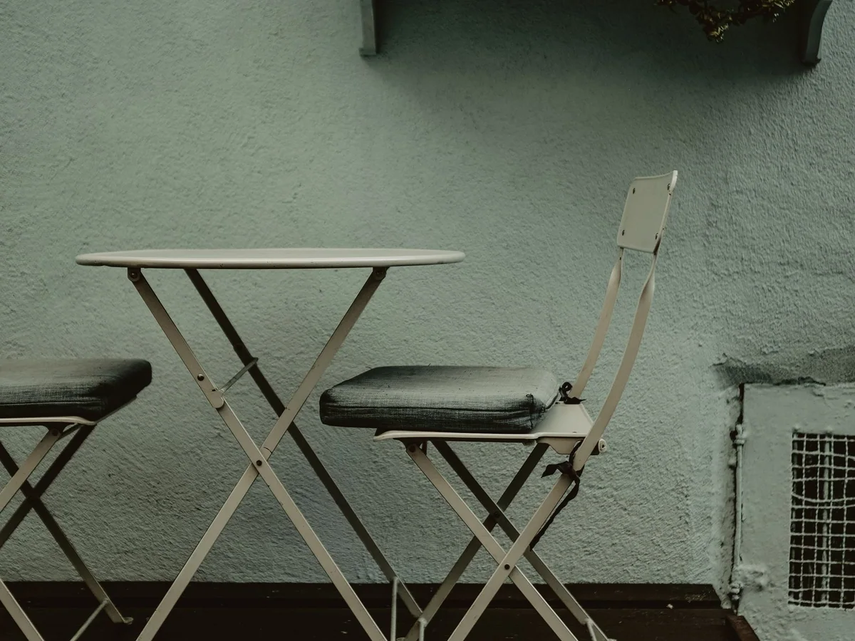A small balcony cafe table and chairs set for morning coffee