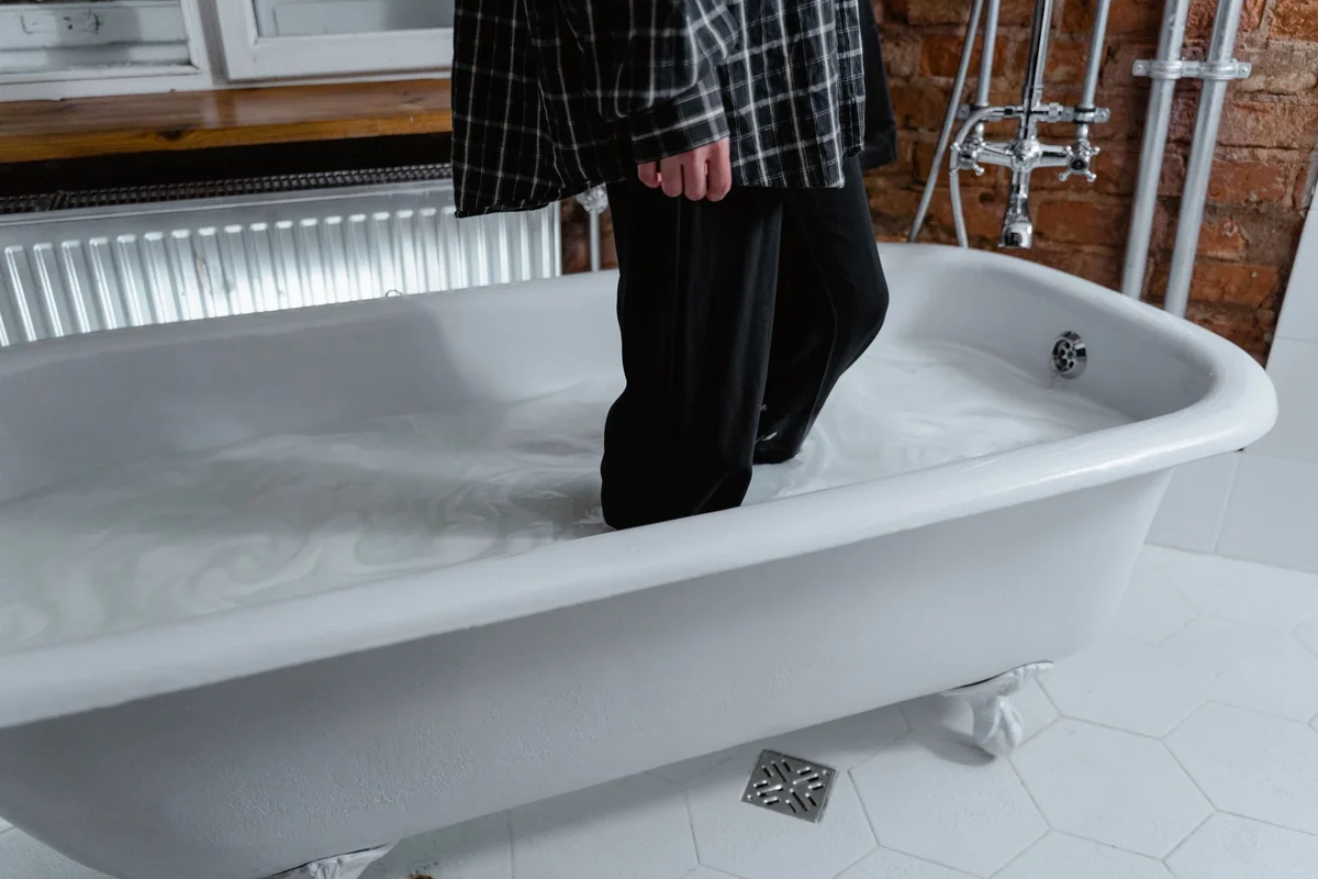 A bath tray holding soap, a book, and a small towel