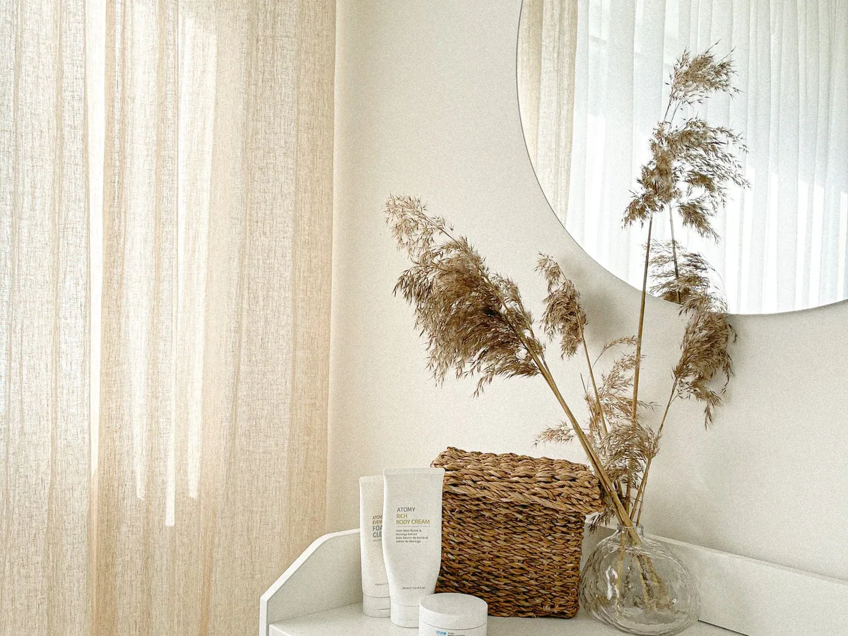 A builder-grade living room softened with linen, wood, and woven textures