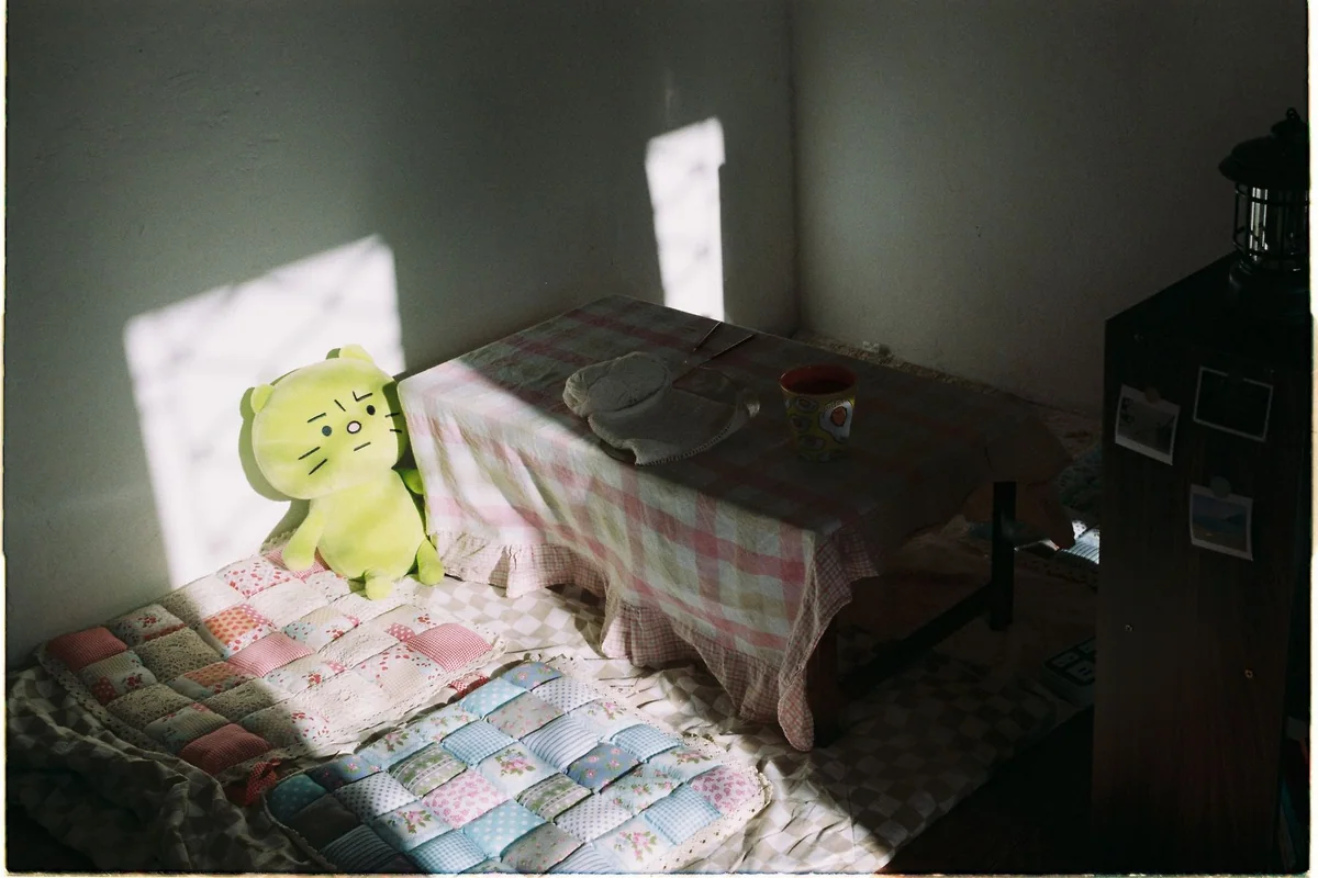 A warm lamp shade glowing above a side table